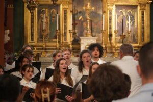 Chor singt vor einem reich geschmückten Kirchenaltar
