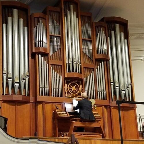 Organist spielt an einer großen Pfeifenorgel in einer Kirche